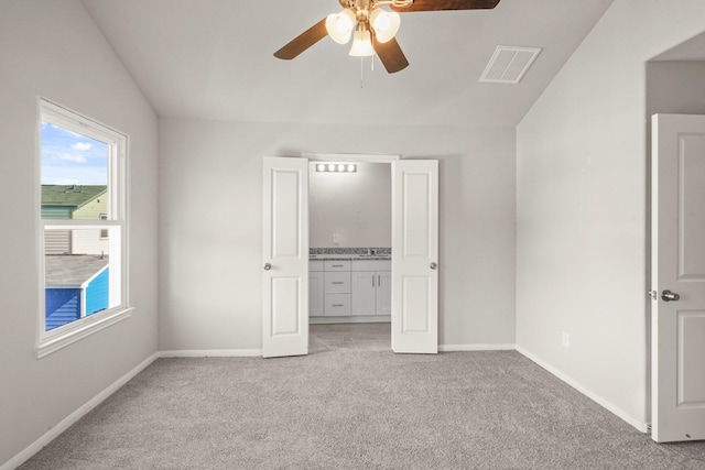 unfurnished bedroom featuring ceiling fan, light carpet, and vaulted ceiling