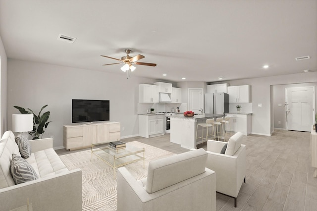 living room featuring ceiling fan and light wood-type flooring