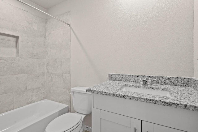 full bathroom featuring tiled shower / bath, vanity, and toilet