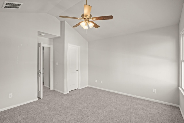 carpeted spare room featuring ceiling fan and lofted ceiling