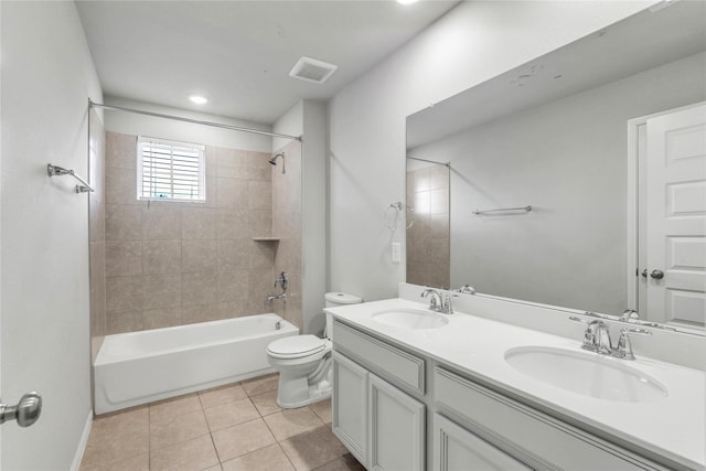 full bathroom with tile patterned flooring, tiled shower / bath combo, toilet, and vanity