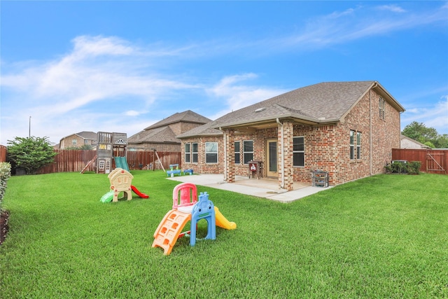 rear view of property featuring a lawn, a playground, and a patio