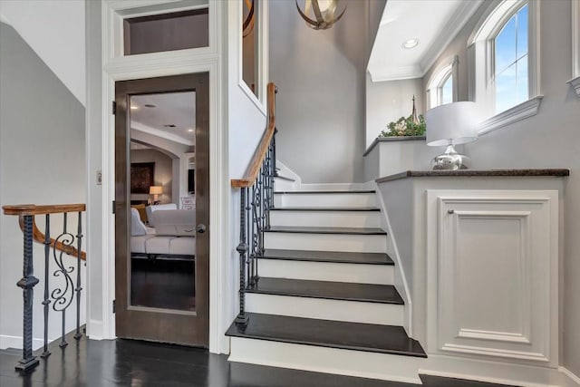 stairway featuring wood-type flooring and ornamental molding