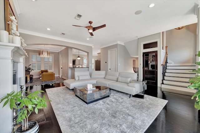 living room featuring ceiling fan with notable chandelier, dark hardwood / wood-style floors, and a multi sided fireplace