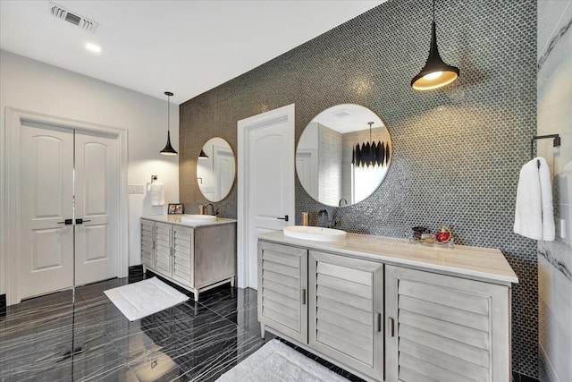 bathroom featuring vanity and tile walls