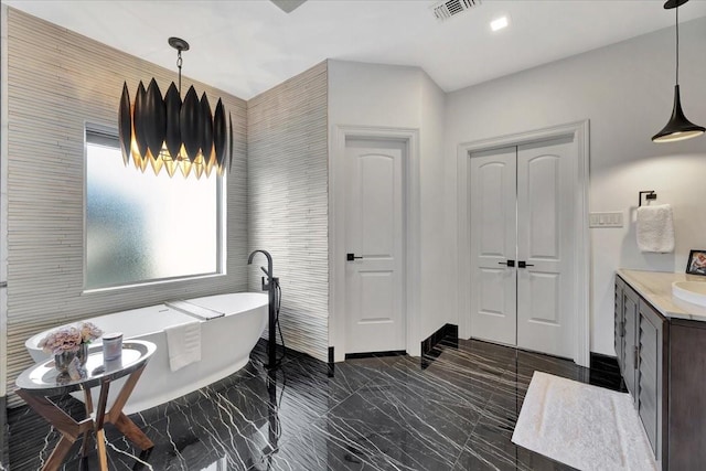 bathroom featuring vanity, a tub to relax in, and tile walls