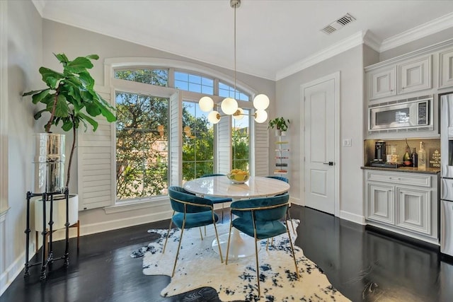 dining room with crown molding, dark wood-type flooring, and a healthy amount of sunlight