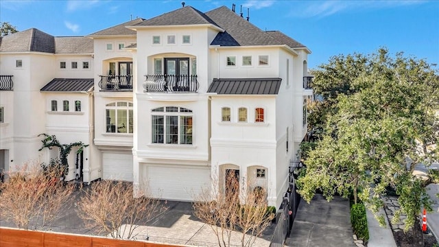 rear view of house with a garage and a balcony