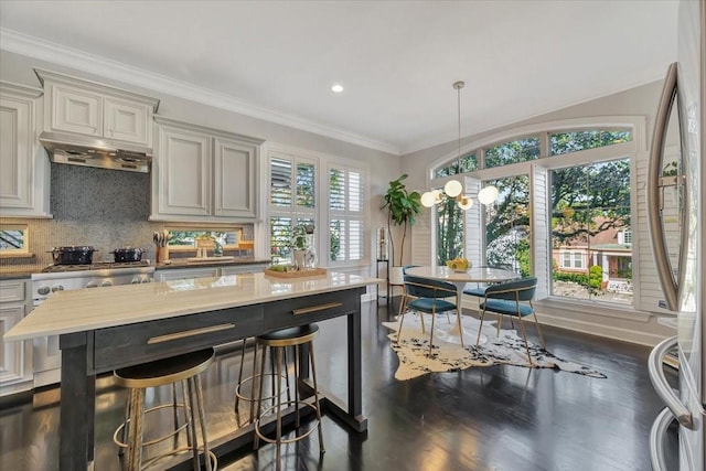 kitchen featuring backsplash, ventilation hood, crown molding, and hanging light fixtures