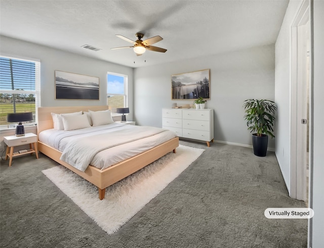 bedroom with ceiling fan and dark carpet