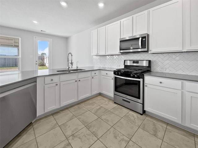 kitchen featuring backsplash, white cabinets, sink, appliances with stainless steel finishes, and light tile patterned flooring