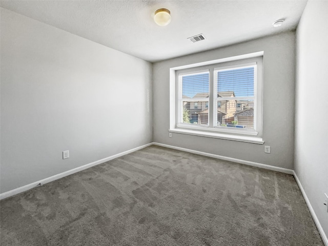 unfurnished room featuring dark colored carpet