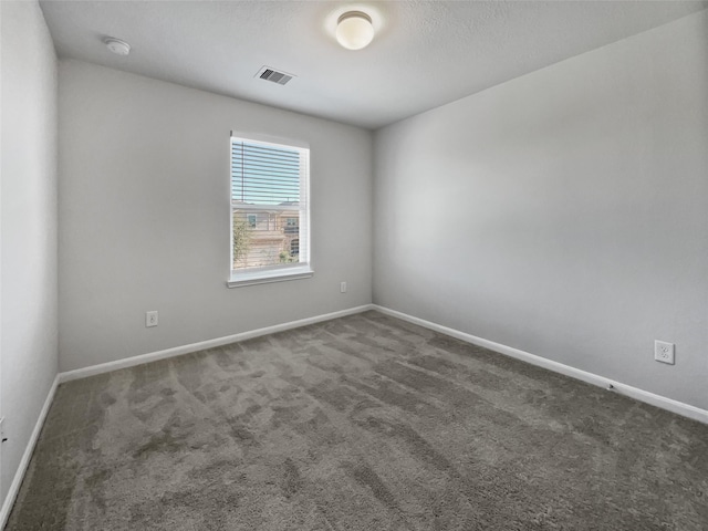 empty room with dark colored carpet