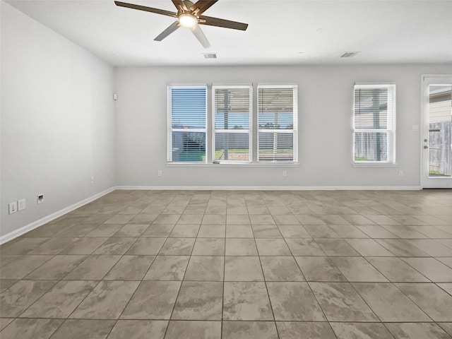 tiled spare room featuring ceiling fan