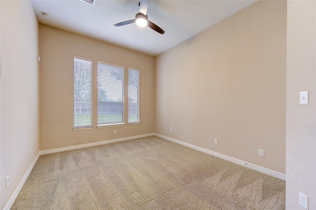 carpeted spare room featuring ceiling fan