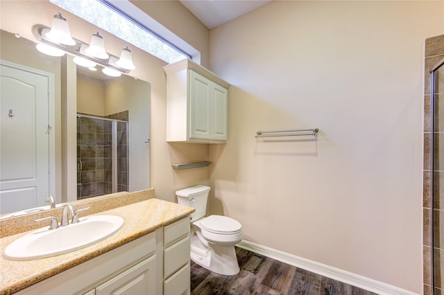 bathroom featuring hardwood / wood-style floors, vanity, toilet, and a shower with door