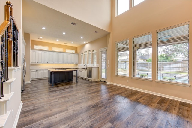 kitchen featuring a kitchen bar, a center island, white cabinetry, and dark wood-type flooring