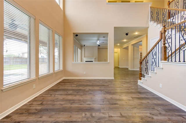 unfurnished living room with a high ceiling and dark hardwood / wood-style floors