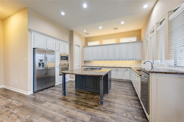 kitchen with a kitchen breakfast bar, a kitchen island, white cabinetry, and stainless steel appliances