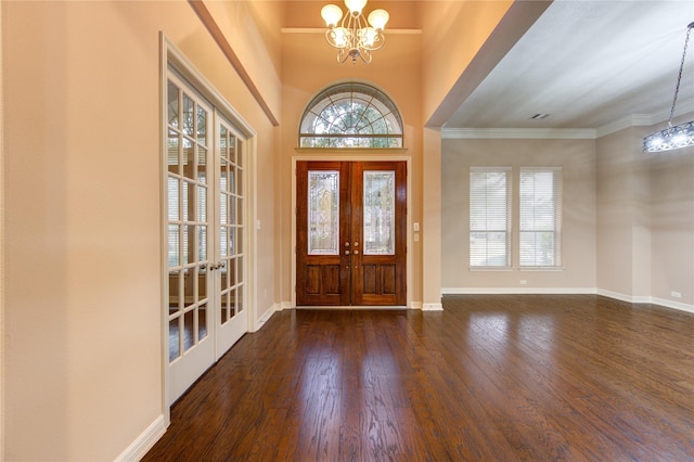 entryway with french doors, dark hardwood / wood-style floors, plenty of natural light, and a notable chandelier