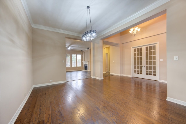 spare room with dark hardwood / wood-style flooring, crown molding, french doors, and a chandelier