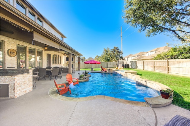 view of pool with a patio area, ceiling fan, and pool water feature