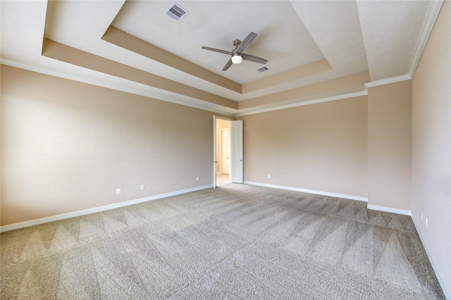 carpeted spare room featuring a tray ceiling, ceiling fan, and ornamental molding