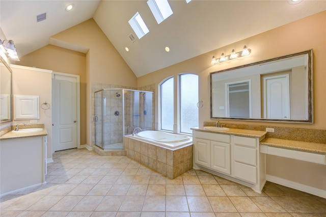 bathroom with tile patterned floors, a skylight, vanity, and high vaulted ceiling