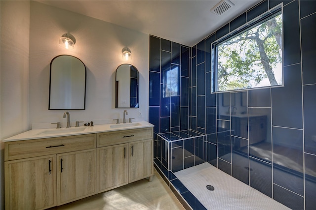 bathroom featuring a tile shower and vanity