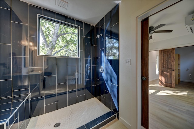 bathroom featuring a tile shower and ceiling fan