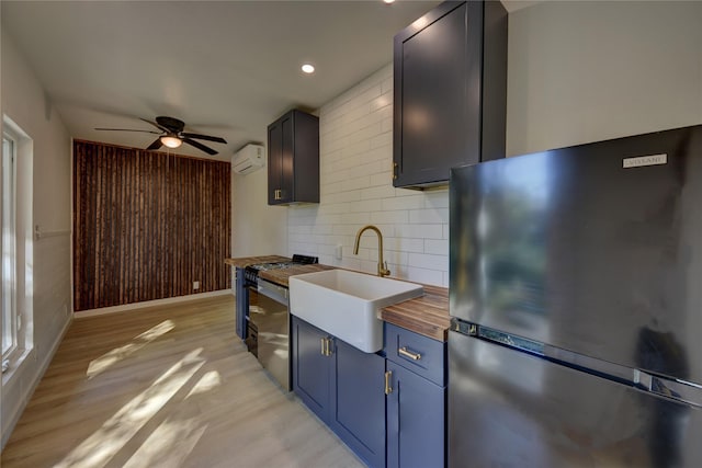 kitchen featuring stainless steel refrigerator, sink, butcher block countertops, an AC wall unit, and decorative backsplash