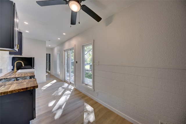 interior space with ceiling fan, sink, and light wood-type flooring