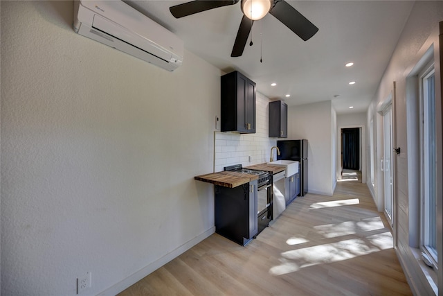 kitchen with light wood-type flooring, backsplash, a wall unit AC, ceiling fan, and butcher block countertops