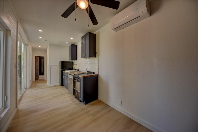 kitchen featuring black appliances, light hardwood / wood-style flooring, ceiling fan, tasteful backsplash, and a wall unit AC