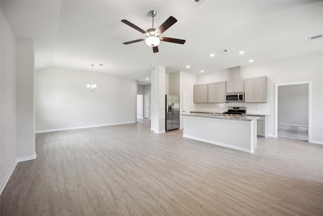 unfurnished living room with ceiling fan, vaulted ceiling, and light wood-type flooring