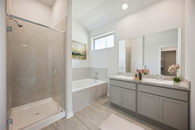 bathroom with hardwood / wood-style floors, vanity, independent shower and bath, and vaulted ceiling