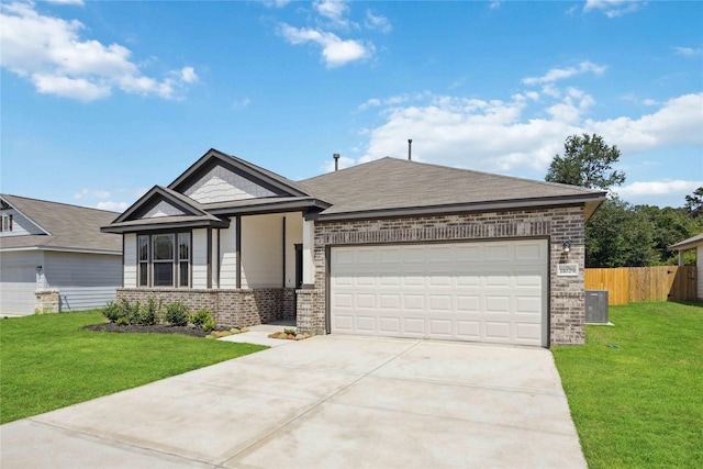 view of front of home featuring a front yard, central AC, and a garage