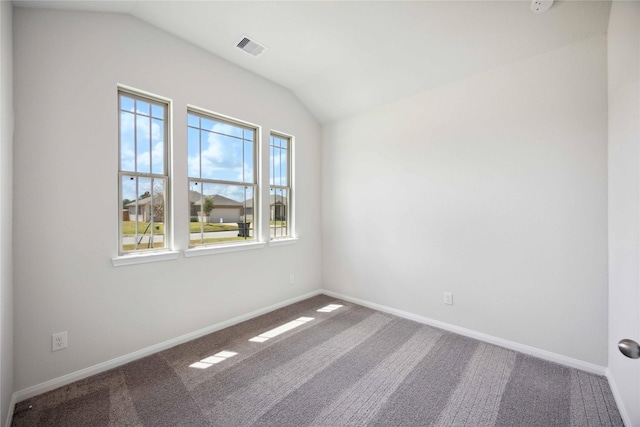 carpeted empty room featuring vaulted ceiling