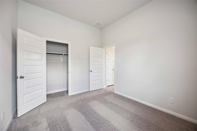 unfurnished bedroom with light carpet and a closet