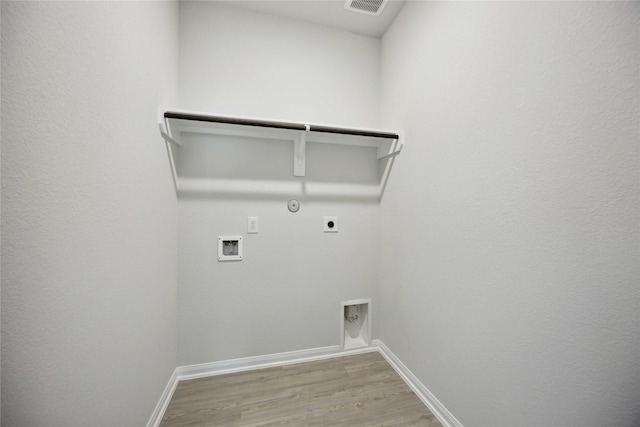 laundry area with hookup for an electric dryer, gas dryer hookup, light wood-type flooring, and hookup for a washing machine