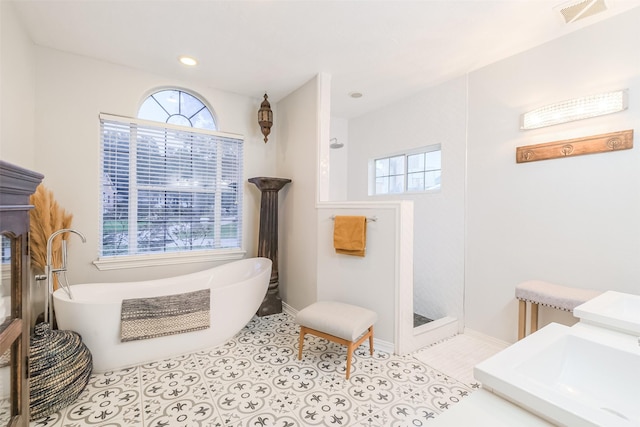 bathroom with tile patterned floors and a bathtub