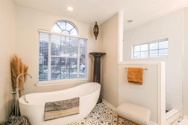 bathroom with tile patterned floors and a washtub