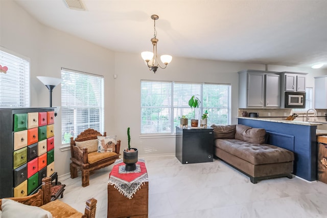 living room with a notable chandelier and sink