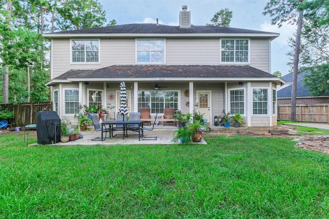 back of property with a yard, a patio, and ceiling fan