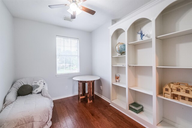 living area featuring ceiling fan and dark hardwood / wood-style floors