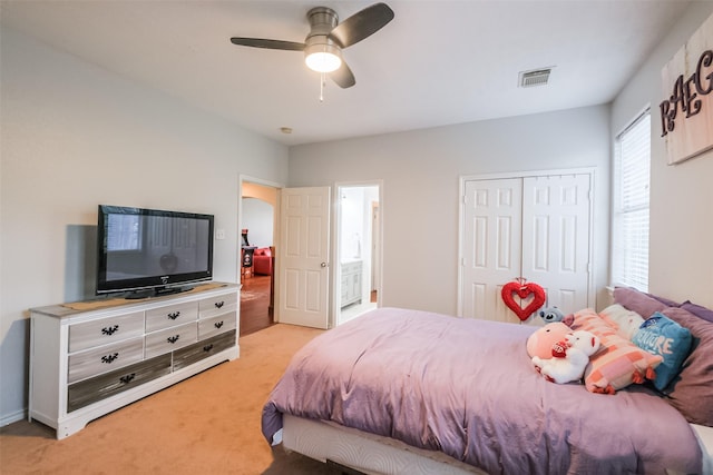 bedroom with light carpet, connected bathroom, a closet, and ceiling fan