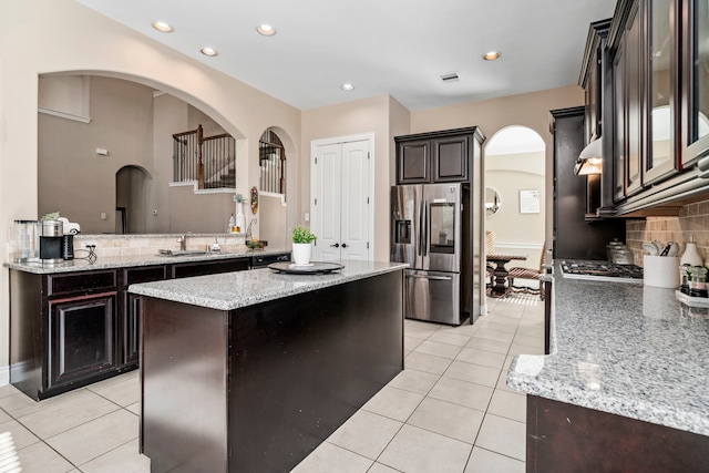 kitchen featuring tasteful backsplash, stainless steel fridge, sink, and light tile patterned flooring