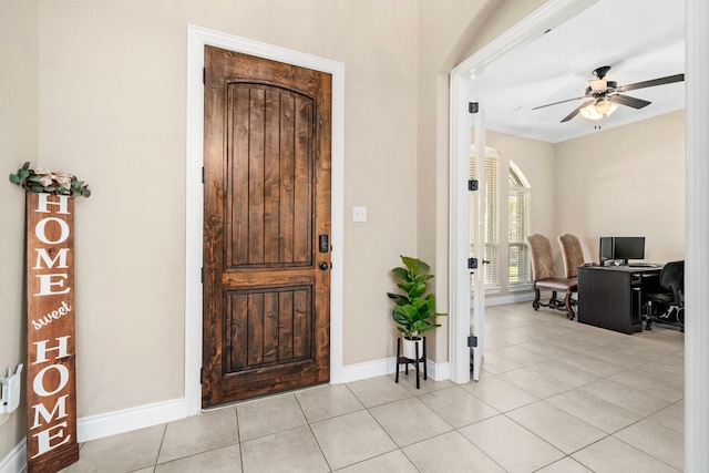 foyer with ceiling fan, light tile patterned floors, and crown molding