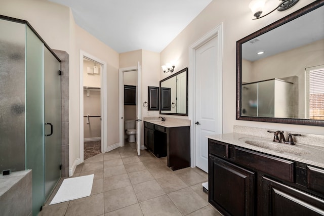 bathroom featuring tile patterned floors, vanity, toilet, and an enclosed shower