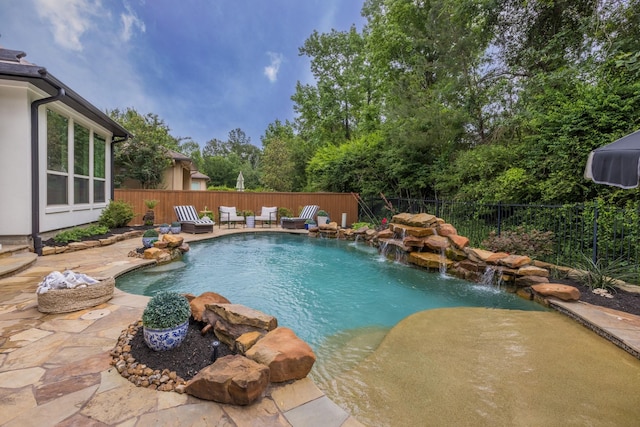 view of swimming pool with pool water feature and a patio area